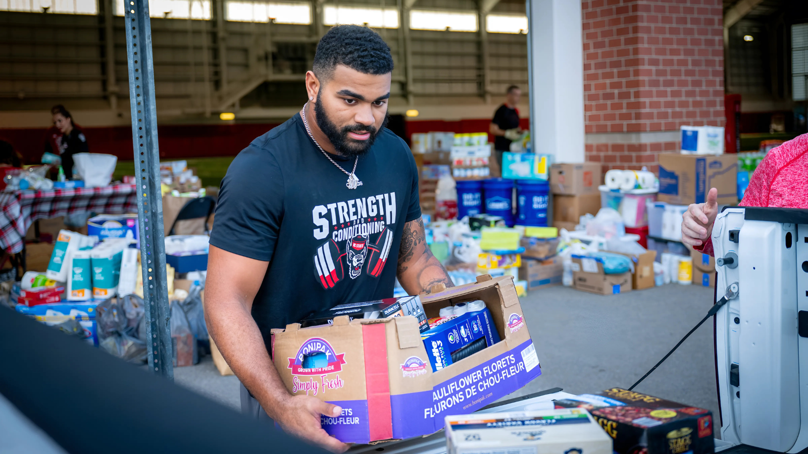 NC State student loading food into a vehicle to support hunger relief.