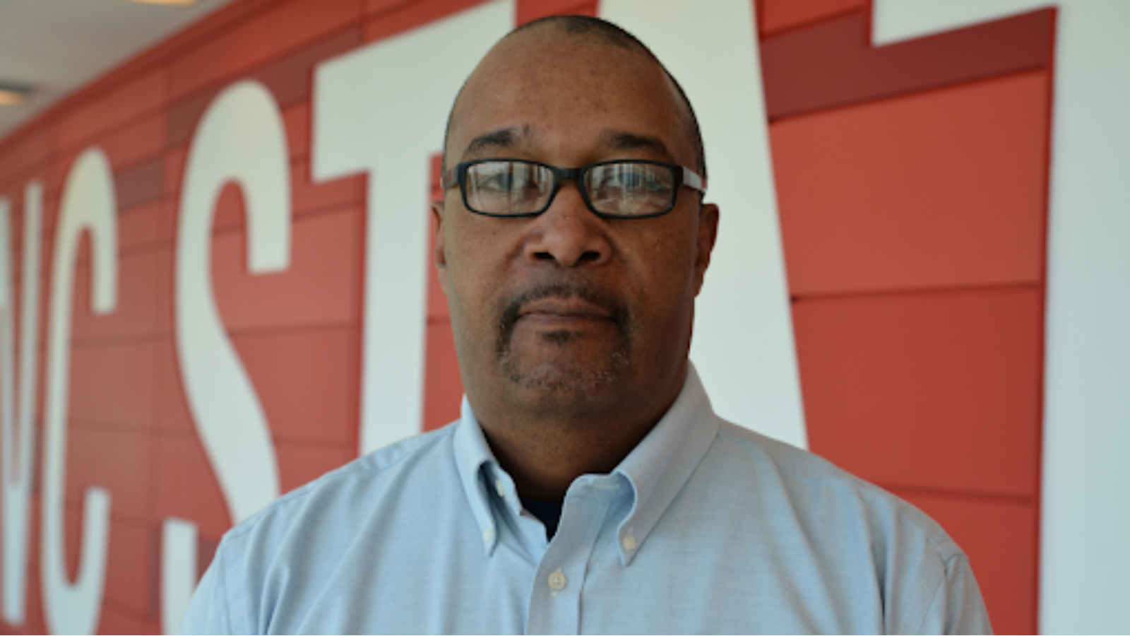 Dr. Kwesi Craig C. Brookins in front of sign