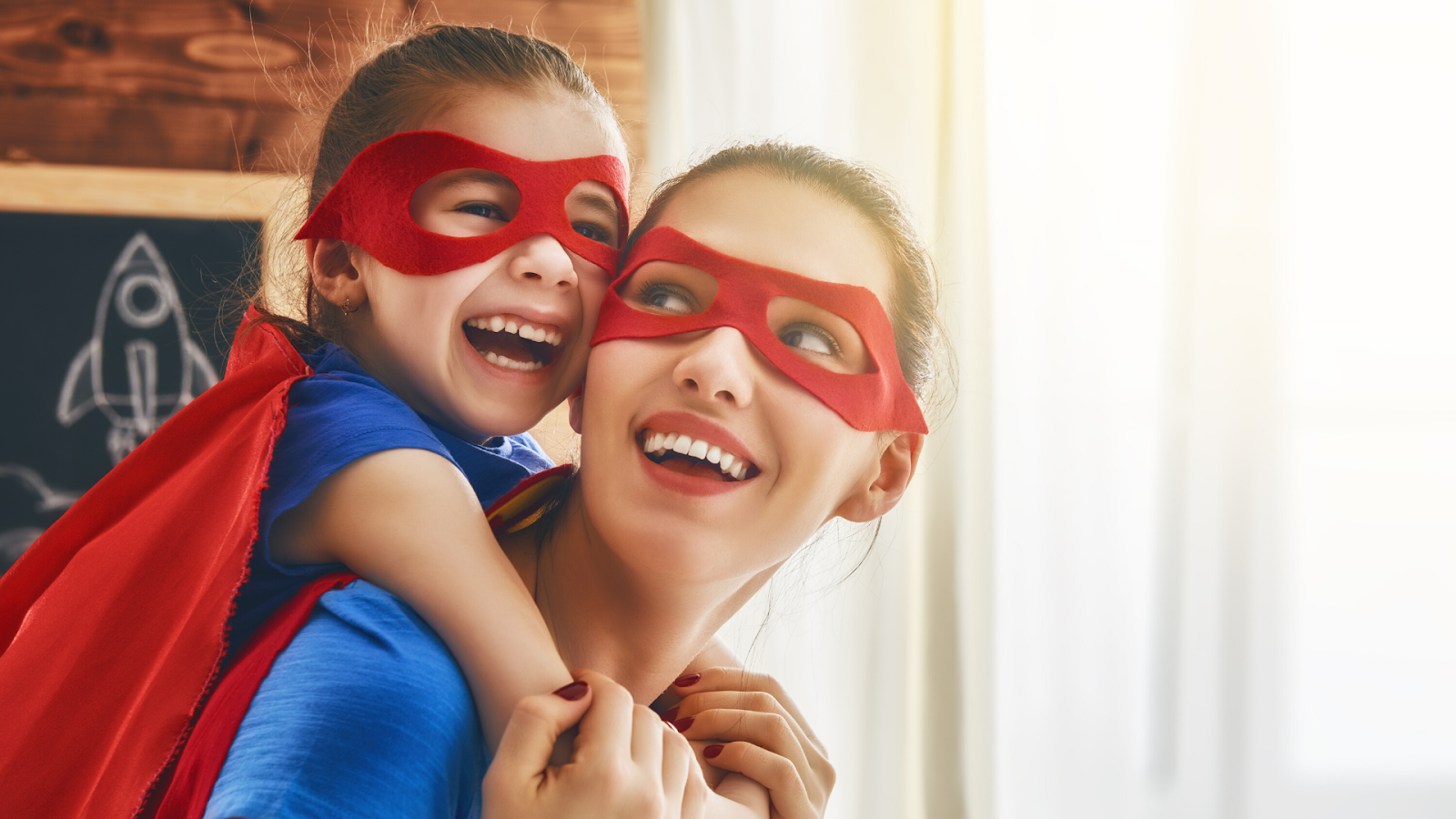 Mom and daughter with super hero outfit on. Child is on mother's back.